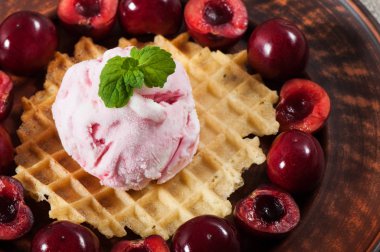 Tatlı bir waffle üzerinde kiraz ile dondurma, nane bir delikanlı ile dekore.