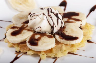 Muz dilimleri ile tatlı waffle çikolata sosu ile döktü.