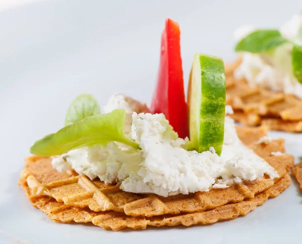 Peynir, otlar, tatlı kırmızı biber, hafif bir arka planda salatalık ile tuzlu waffle.