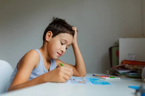 Sötét Hajú Fiú Rajzol Egy Képet Ceruzával Miközben Fehér Asztal — Stock Fotó