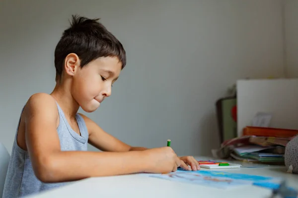 Темноволосий Хлопчик Малює Картину Олівцями Сидячи Білим Столом — стокове фото