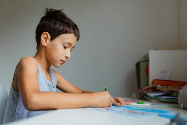 Темноволосий Хлопчик Малює Картину Олівцями Сидячи Білим Столом — стокове фото