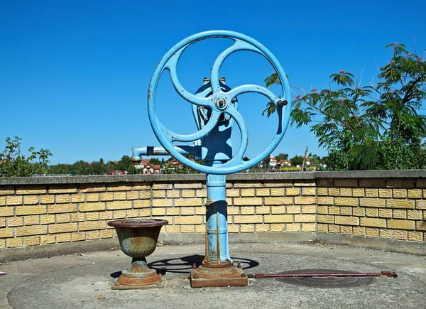 Pompa per pozzo d'acqua blu, con ruota, sul sole estivo — Foto Stock