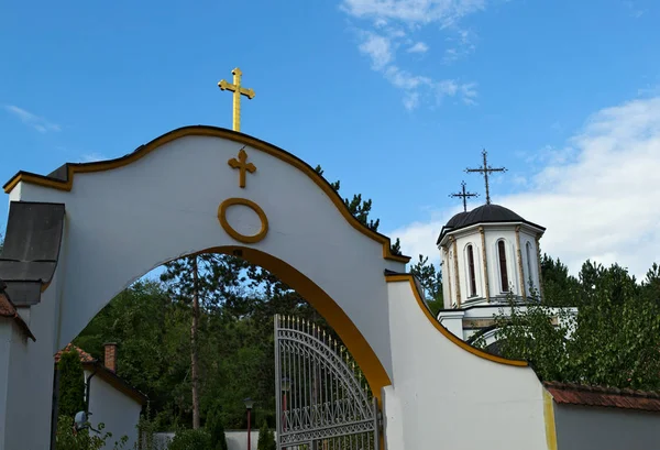 Entrance to a monastery and church tower in background — Stock Photo, Image