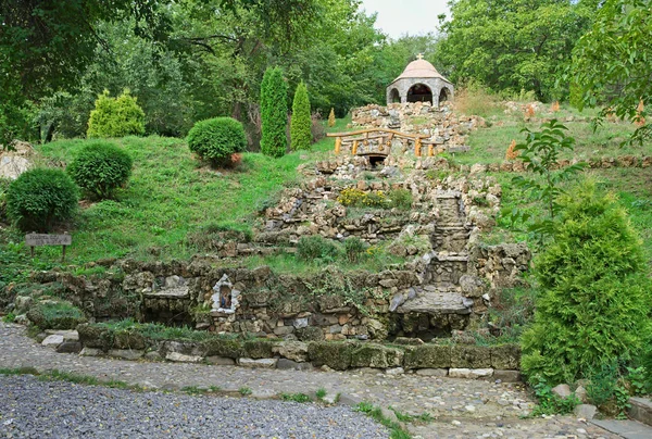 Grande fontaine en pierre sèche et chapelle au sommet de la colline — Photo
