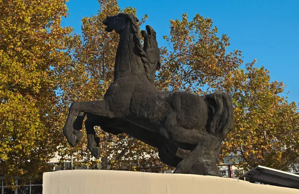 Monument of two horses in front of autumn trees — Stock Photo, Image