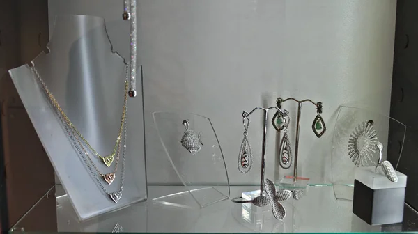 Различные элегантные женские украшения в стеклянной коробке — стоковое фото