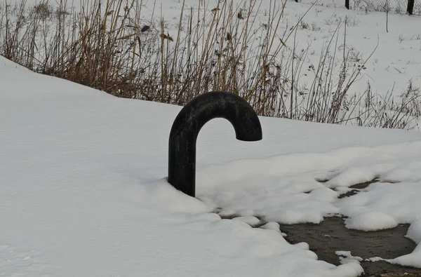 Tubo de escape de esgoto fora com neve ao redor — Fotografia de Stock