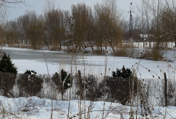 Paisaje de invierno con el canal congelado y la nieve alrededor — Foto de Stock