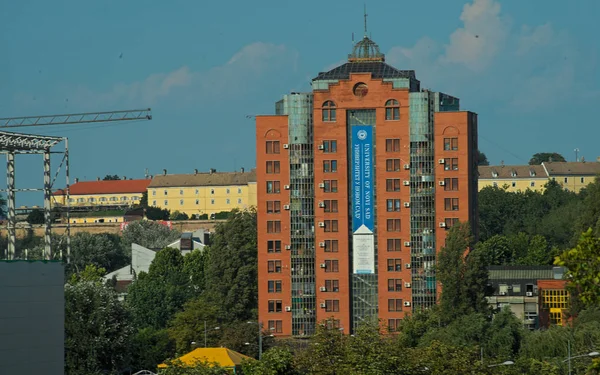 Näkymä punatiilinen rakennus ja Petrovaradin linnoitus taustalla — kuvapankkivalokuva