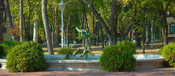 Ortasında fıskiye ve heykel olan bir park. — Stok fotoğraf