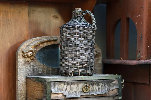 Carboy Wicker Basket Wooden Table Old Demijohn Wicker Wrapped Glass — Stock Photo, Image