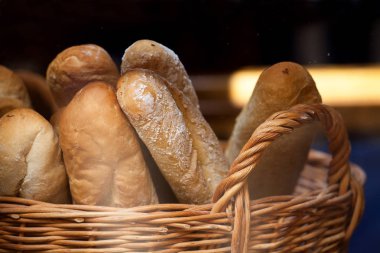 Ekmek somunları ve baget hasır sepetin içinde. Ekmek pişirme dükkanda bir sepet içinde
