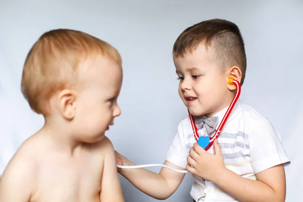 Children playing doctor and patient. Two little boys using stethoscope. Check the heartbeat. Kids play doctor