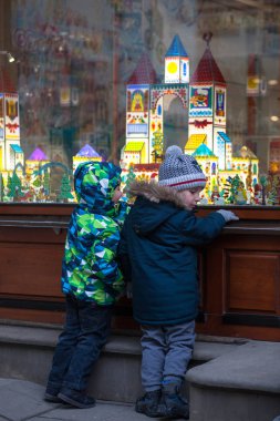 Ukrayna, Lviv - 6 Aralık 2018. Dükkanı penceresine bakarak bir Lviv sokakta iki küçük çocuklar Noel için dekore edilmiştir. Harika Vitrini