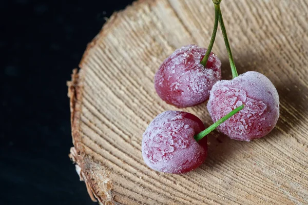 Cerejas congeladas em uma mesa de madeira — Fotografia de Stock