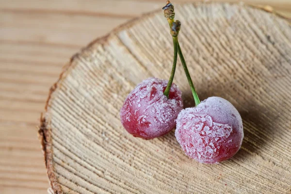 Duas cerejas congeladas em um fundo de madeira — Fotografia de Stock