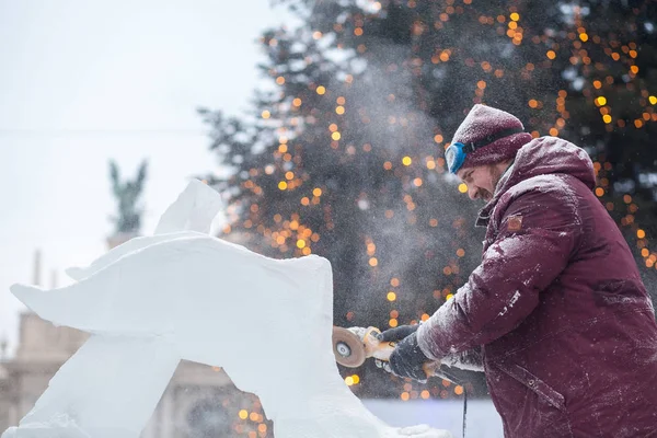 Ukrayna, Lviv - 11 Ocak 2019: Master buz buz heykeller yapar. Testere ile buz buz kontür heykeltıraş keser
