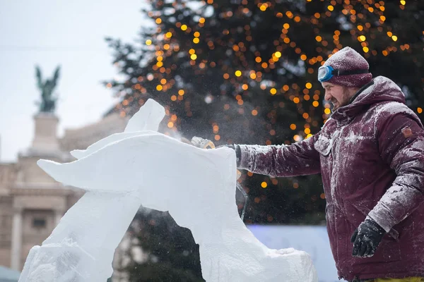 Ukrayna, Lviv - 11 Ocak 2019: Master buz buz heykeller yapar. Testere ile buz buz kontür heykeltıraş keser