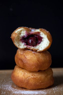 Siyah arka plan üzerine kiraz ile Donuti. Taze çörek.