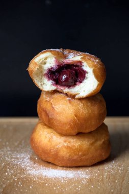 Siyah arka plan üzerine kiraz ile Donuti. Taze çörek.