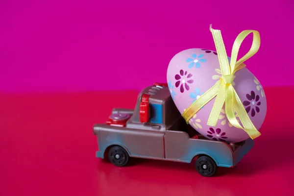 Pickup toy carrying one decorated easter egg. Easter holiday concept