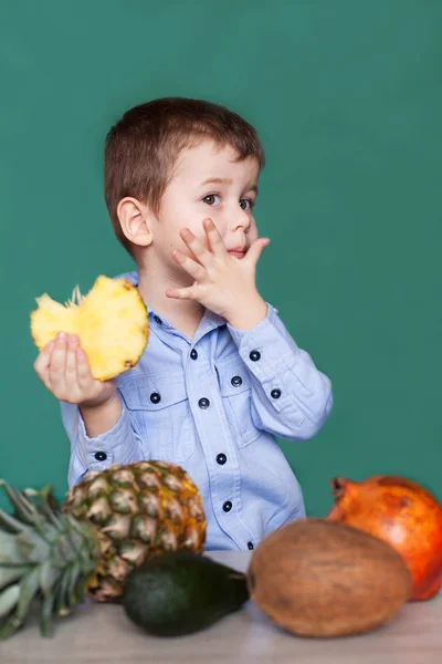 Lindo niño comiendo piña. Concepto de alimentación saludable . — Foto de Stock