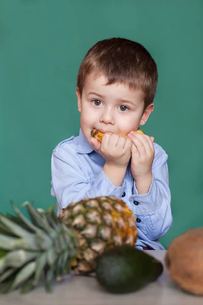 Lindo niño comiendo piña. Concepto de alimentación saludable . — Foto de Stock