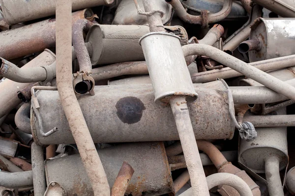 Stapel gebrauchter Schalldämpfer in der Autowerkstatt. viele Auspuffrohre in absolut keiner Reihenfolge gestapelt — Stockfoto