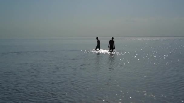 Silhouetten Van Twee Jonge Mannen Gaan Knieën Het Water — Stockvideo