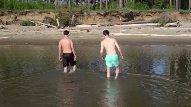 Twee Jonge Mannen Komen Uit Het Water Naar Wal — Stockvideo
