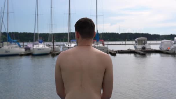 Młody Człowiek Siedzi Molo Patrzy Jachty Film Pochodzi Tyłu — Wideo stockowe