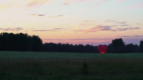 Aerostato Vermelho Forma Coração Fica Por Sol Nos Campos Panorâmica — Vídeo de Stock