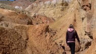 Çekici bir kız kanyonda yürür ve geri görünüyor