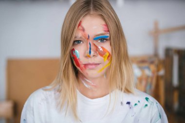 Boya yüzünde bir genç çekici sanatçı portresi.