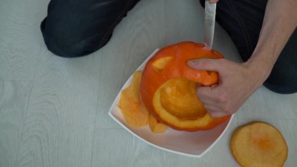 Corta una calabaza para Halloween en el piso blanco — Vídeo de stock