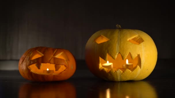 Twee Halloween pompoenen in een donkere kamer — Stockvideo