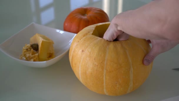 Las manos masculinas sacan las entrañas de una calabaza — Vídeos de Stock