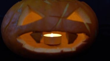 Cadılar Bayramı için parlayan balkabağı. El video, atış yakın çekim mum sonra kabak.