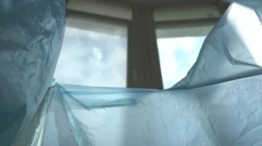 Çöpe plastik atar. Çöp kutusundan görünüm.