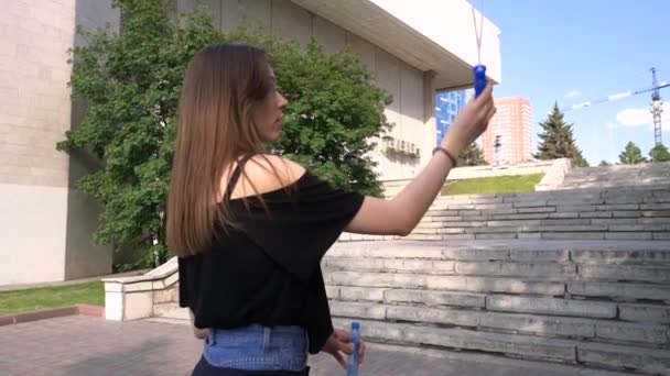 Das Mädchen Macht Seifenblasen Auf Der Straße Vor Dem Hintergrund — Stockvideo