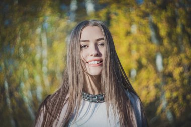 Bulanık sonbahar arka plan üzerinde mutlu bir kız portresi.