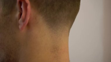 Berber saç makasıyla bir adamın saçlarını kesiyor..