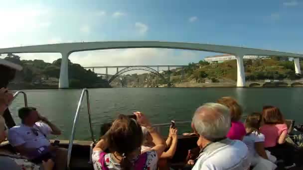 Turisták egy csónakban, amely bekapcsolja a Douro-folyón közeledik a Ponte Do Freixo, Porto, Portugália — Stock videók