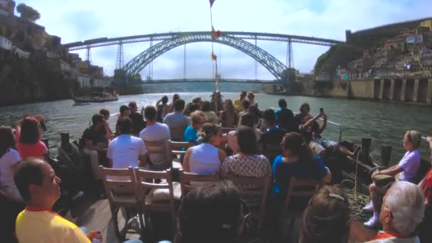 TURISTAS EN UN BARCO POR EL RÍO DOURO YENDO A LUIS I PUENTE DE PORTO, PORTUGAL — Vídeos de Stock