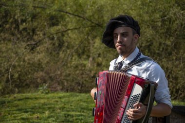 Açık havada mızıka çalan tipik kostümlü Gaucho çocuğu..