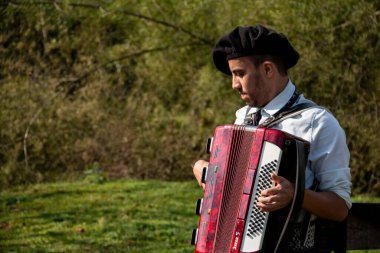 Açık havada mızıka çalan tipik kostümlü Gaucho çocuğu..