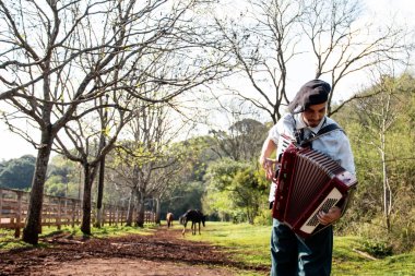 Gaucho ayakta mızıka çalıyor..
