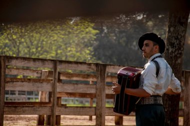 Açık havada mızıka çalan tipik kostümlü Gaucho çocuğu..