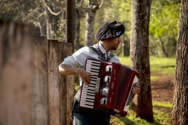 Açık havada mızıka çalan tipik kostümlü Gaucho çocuğu..
